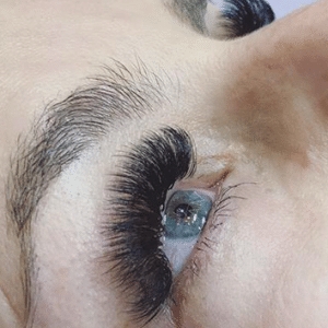 Eyelash extensions creating a lifted, eye-opening effect.